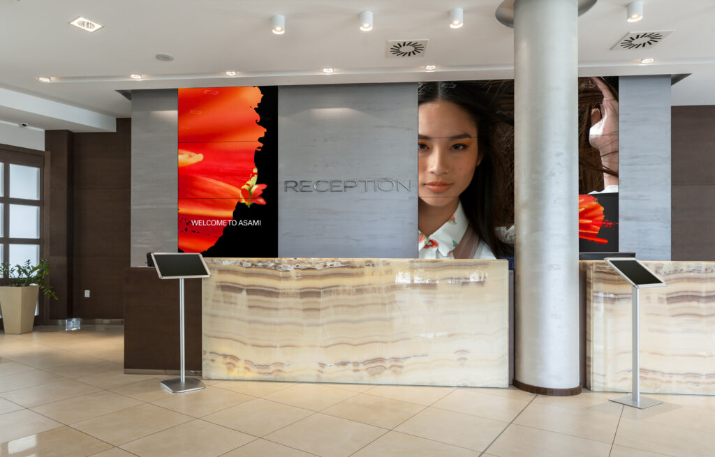 Reception area with multiple tiles screens displaying information to visitors